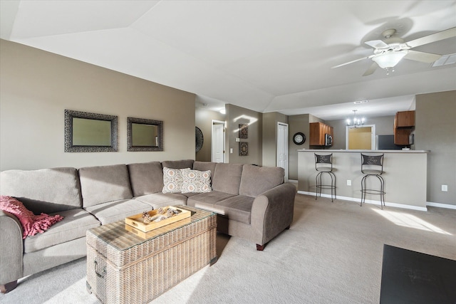 living room with ceiling fan with notable chandelier, light colored carpet, and lofted ceiling