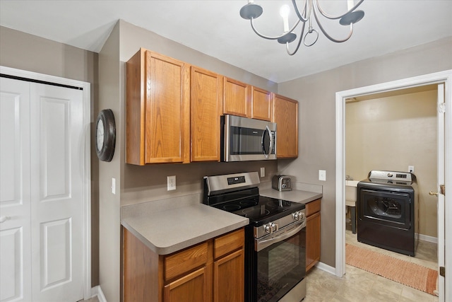 kitchen featuring a chandelier, pendant lighting, stainless steel appliances, and washer / clothes dryer