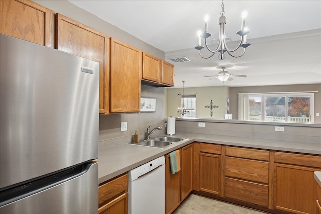 kitchen with stainless steel fridge, ceiling fan with notable chandelier, sink, decorative light fixtures, and dishwasher