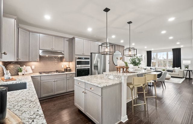 kitchen featuring gray cabinetry, sink, a center island, and appliances with stainless steel finishes