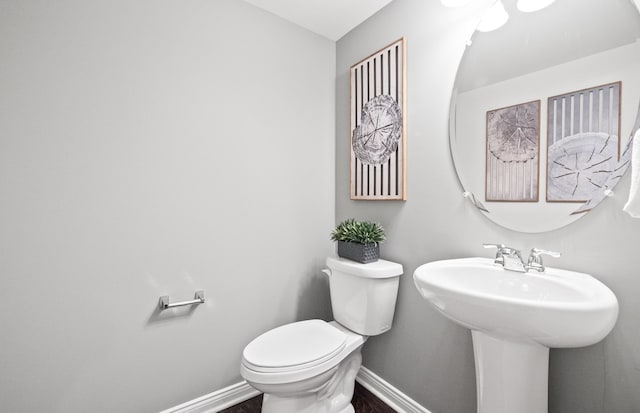 bathroom featuring hardwood / wood-style flooring, toilet, and sink