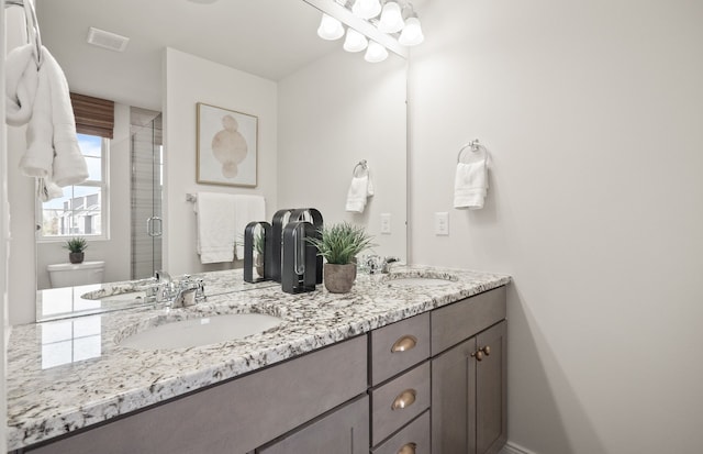 bathroom with vanity, toilet, and a shower with shower door