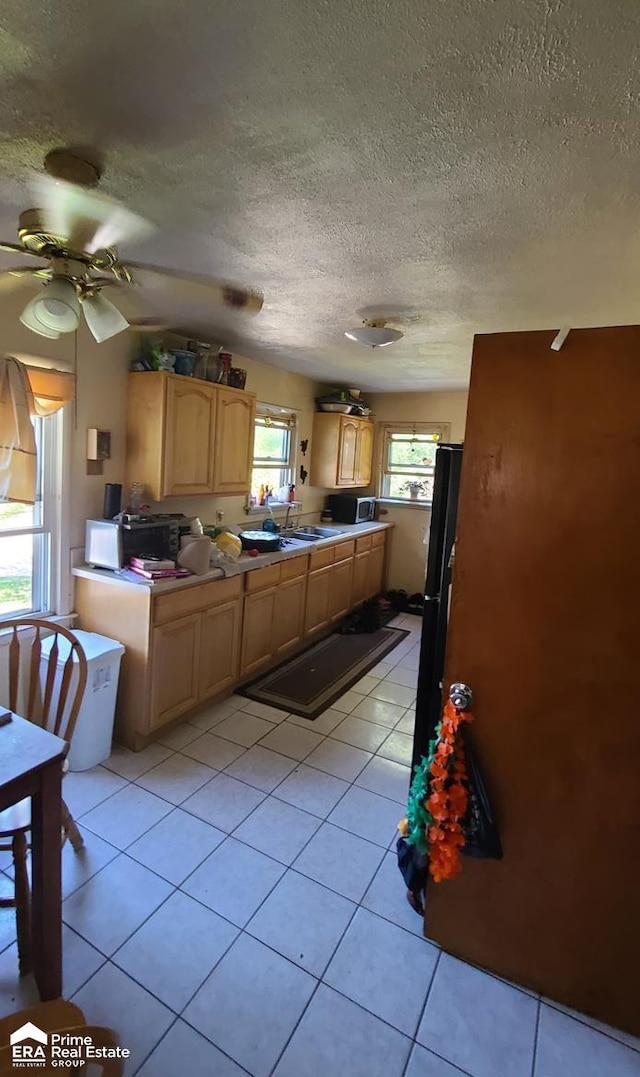 kitchen featuring ceiling fan, light tile patterned floors, a textured ceiling, and a wealth of natural light