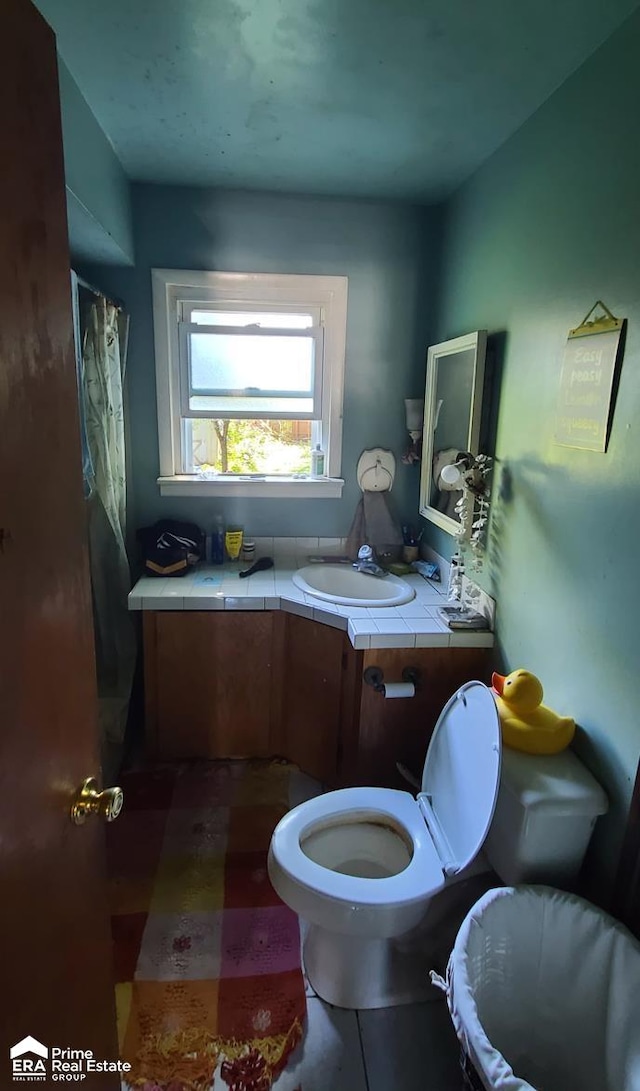 bathroom featuring tile patterned flooring, vanity, and toilet