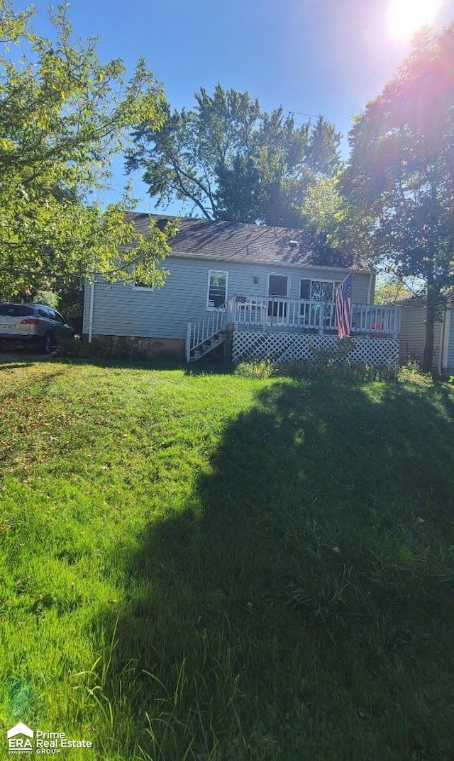 rear view of house with a yard and a wooden deck