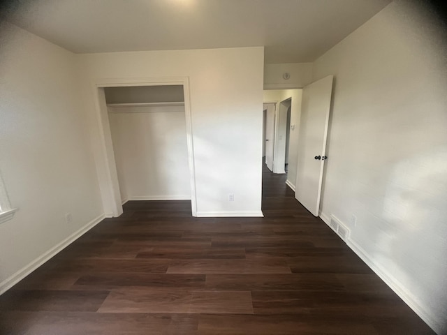 1060 Cross St, Saginaw, MI 48602 - unfurnished bedroom featuring dark wood finished floors, baseboards, and a closet