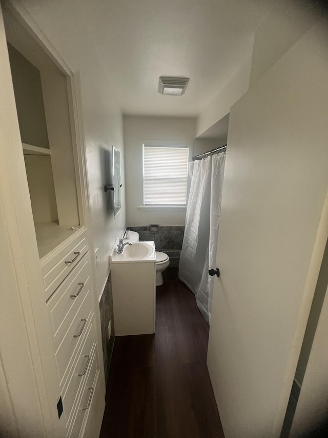 1060 Cross St, Saginaw, MI 48602 - full bath with vanity, wood finished floors, toilet, and a shower with curtain