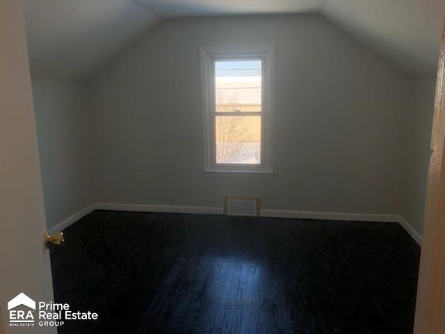 1404 E Kurtz Ave, Flint, MI 48505 - additional living space with vaulted ceiling, hardwood / wood-style floors, and baseboards