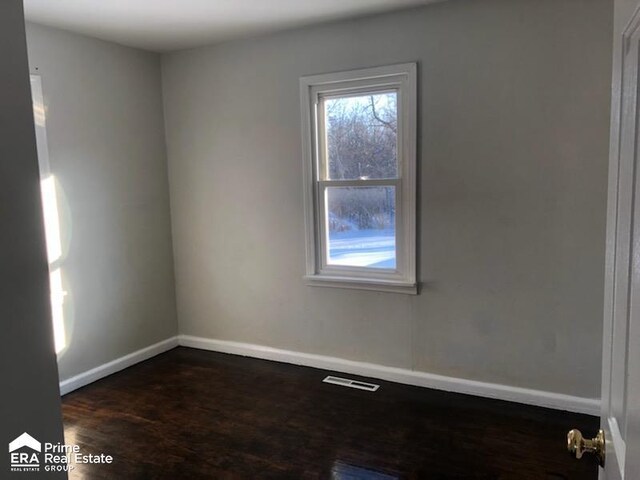 1404 E Kurtz Ave, Flint, MI 48505 - empty room with healthy amount of natural light, dark wood-style flooring, and baseboards