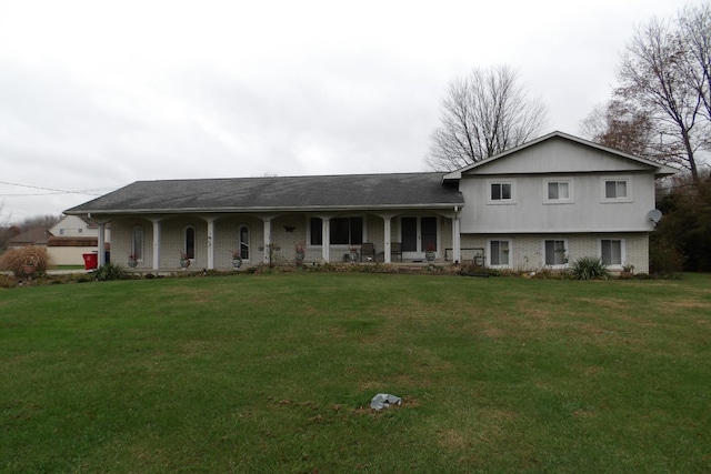 tri-level home featuring covered porch and a front yard