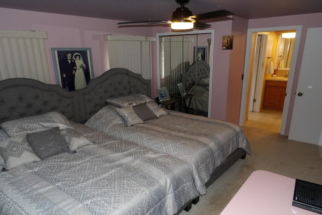 carpeted bedroom with ceiling fan, ensuite bath, and a closet