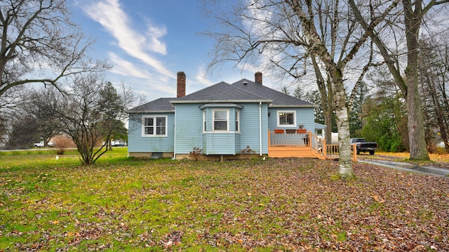 back of house featuring a wooden deck and a yard