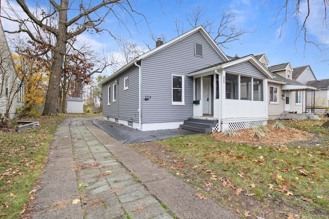 bungalow featuring a sunroom and an outbuilding