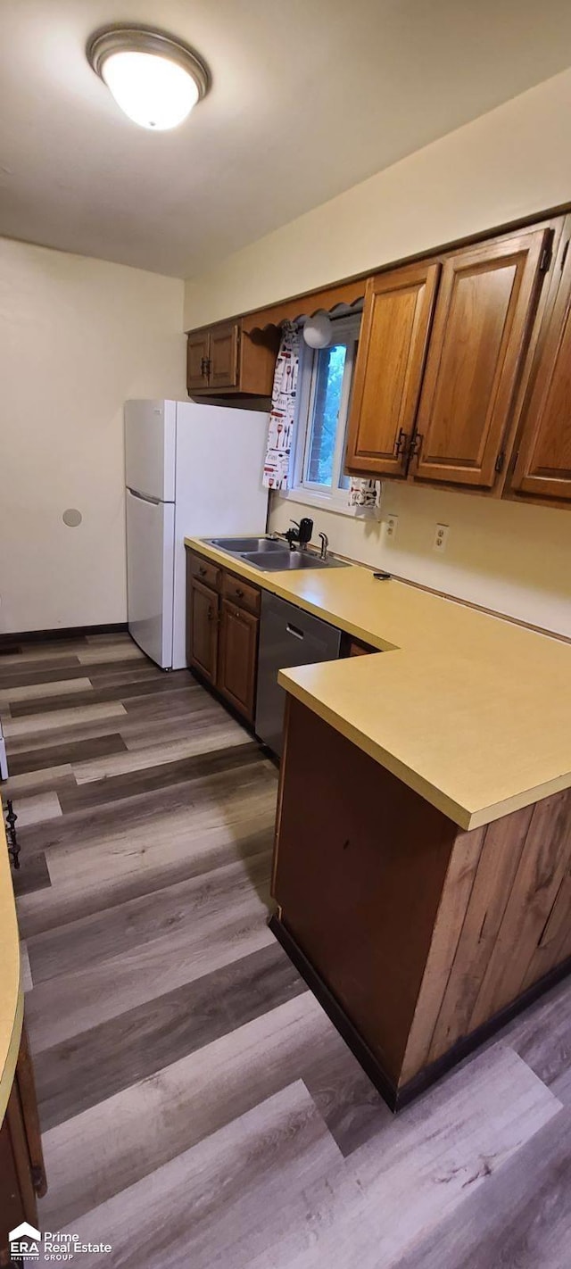 1587 Mcalpine Dr, Mount Morris, MI 48458 - kitchen with light countertops, dark wood-type flooring, a peninsula, a sink, and brown cabinetry