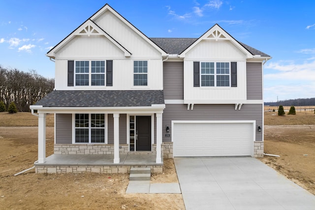 view of front of home featuring a shingled roof, concrete driveway, covered porch, a garage, and stone siding