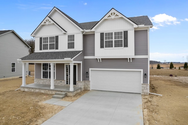 view of front of property with a garage, covered porch, driveway, and roof with shingles