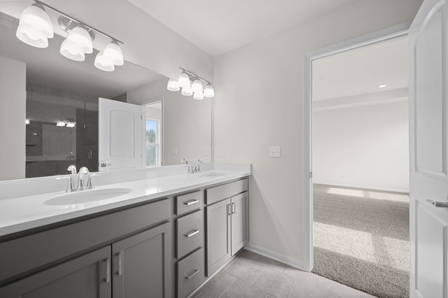 bathroom featuring double vanity, a shower stall, tile patterned floors, and a sink