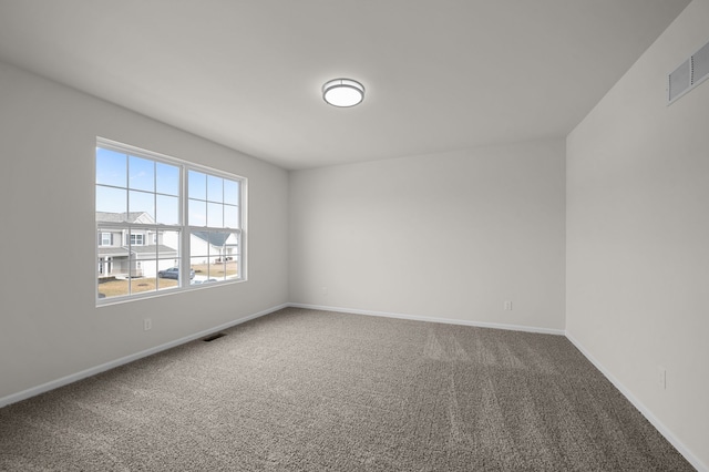 spare room with baseboards, visible vents, and carpet floors