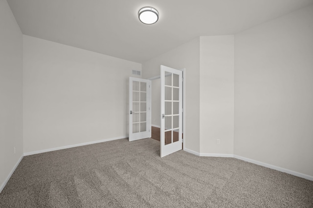 empty room with carpet flooring, french doors, baseboards, and visible vents