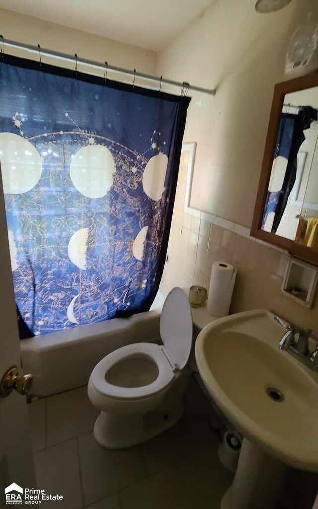 2840 Mallery St, Flint, MI 48503 - bathroom featuring shower / bath combination with curtain, tile patterned floors, toilet, a sink, and tile walls