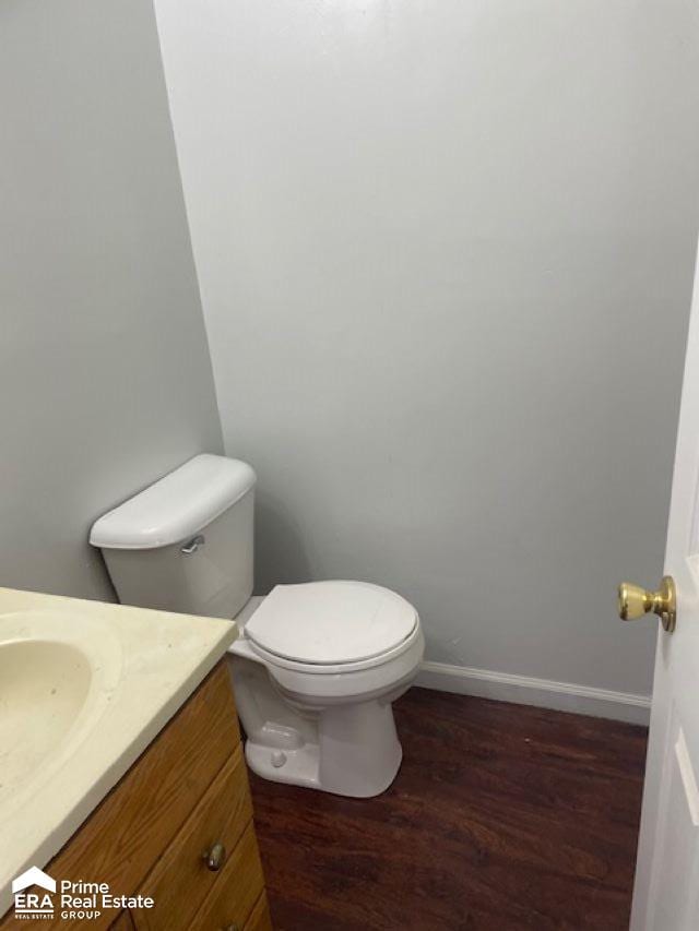 bathroom with hardwood / wood-style floors, vanity, and toilet