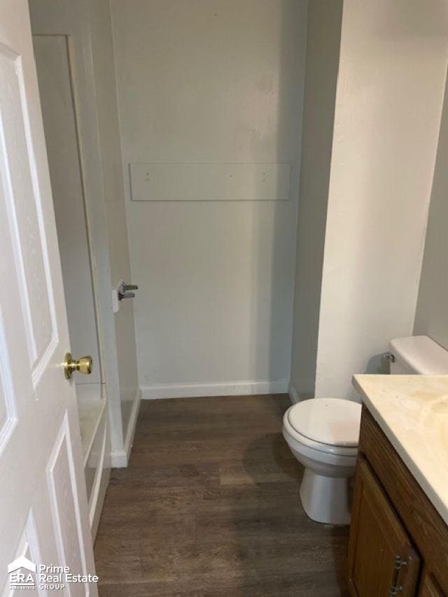 bathroom with hardwood / wood-style floors, vanity, and toilet