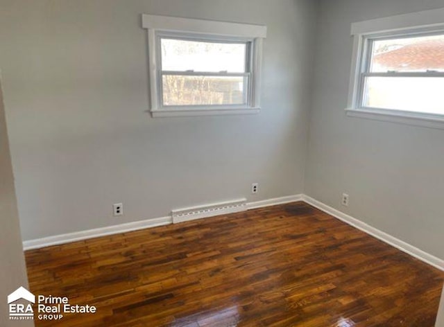 unfurnished room with a healthy amount of sunlight and dark wood-type flooring