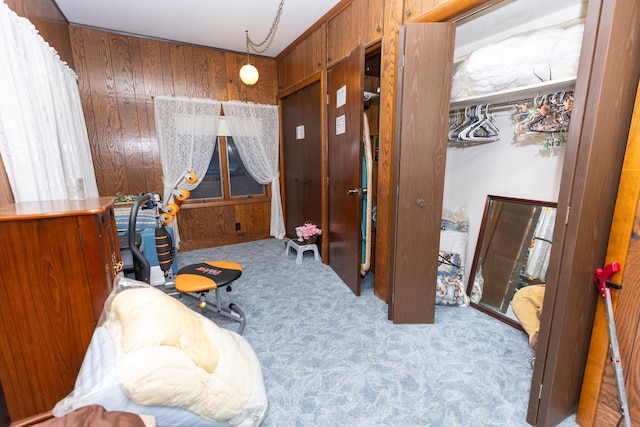 carpeted bedroom featuring wooden walls