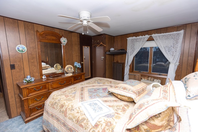 carpeted bedroom with wooden walls and a ceiling fan