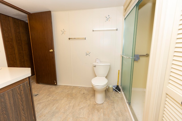 bathroom featuring a shower stall, toilet, and vanity