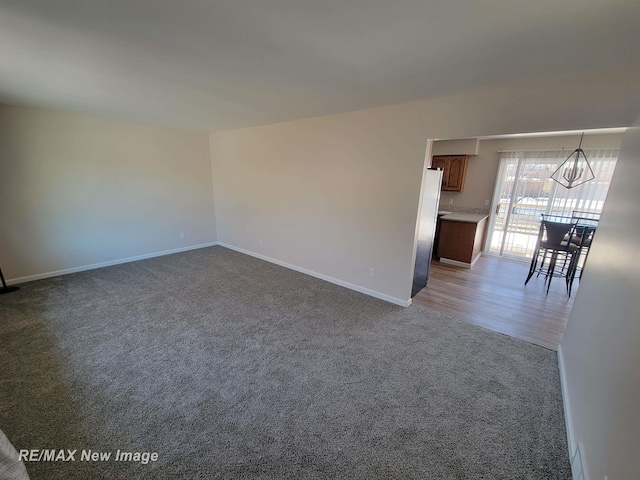 empty room featuring carpet floors and an inviting chandelier