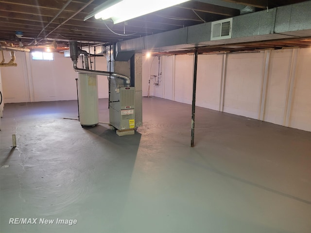 basement featuring heating unit and water heater