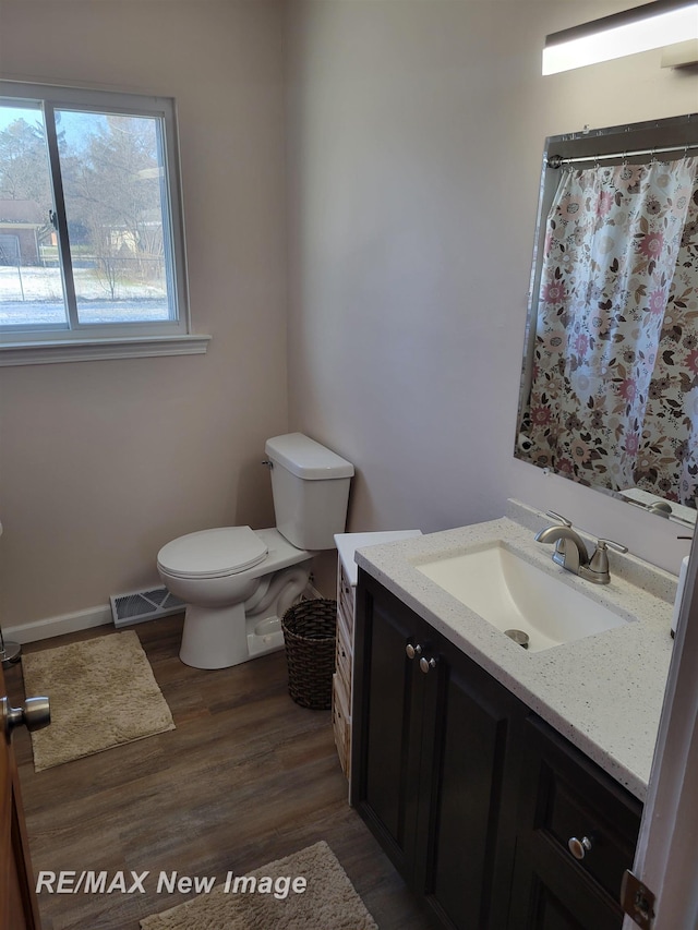 bathroom featuring vanity, hardwood / wood-style flooring, and toilet