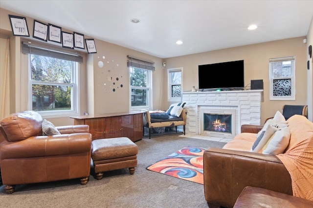 living room featuring light carpet, a stone fireplace, and plenty of natural light