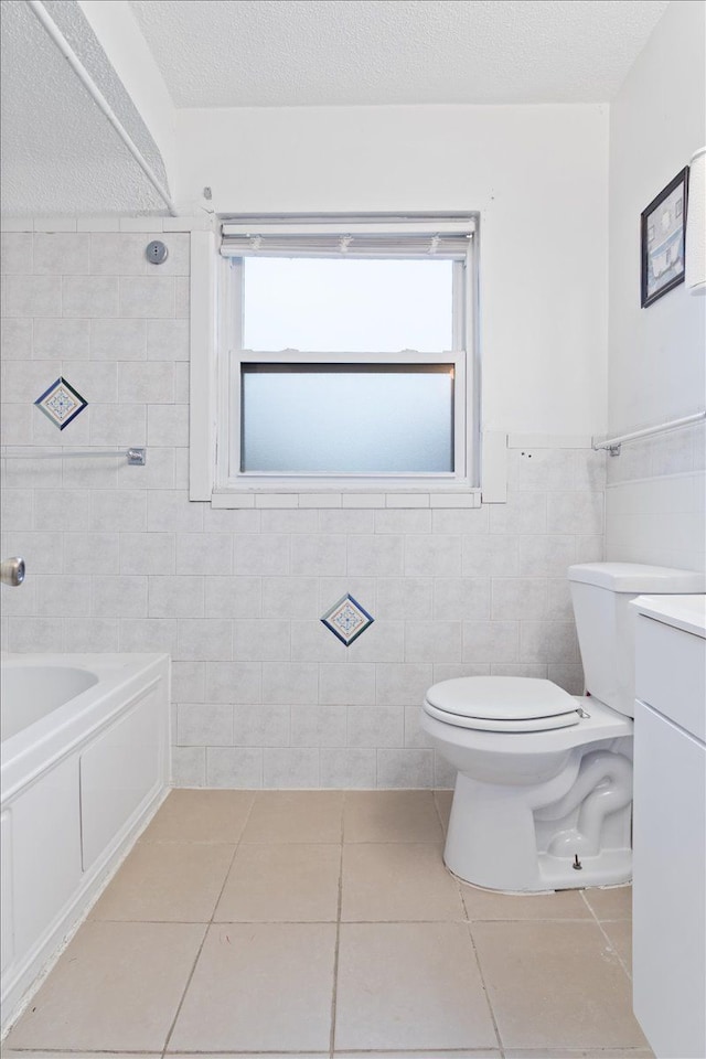 full bathroom with tile patterned floors, tile walls, a textured ceiling, toilet, and shower / bathtub combination