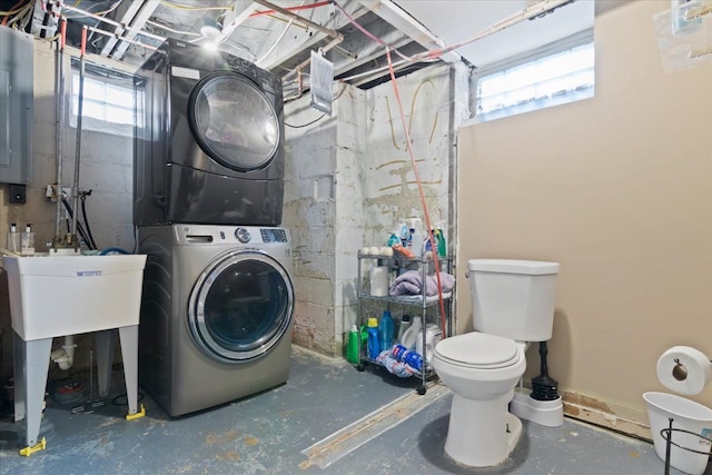 washroom featuring stacked washer and dryer and plenty of natural light