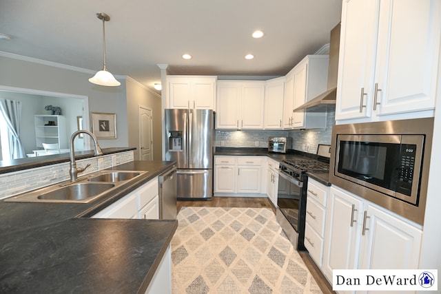 kitchen featuring pendant lighting, sink, crown molding, appliances with stainless steel finishes, and white cabinetry