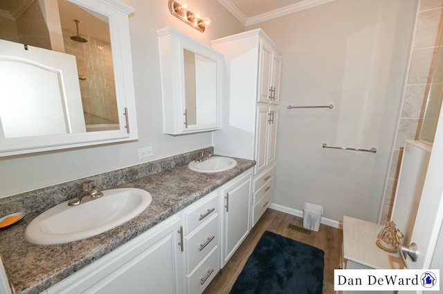 bathroom featuring crown molding, wood-type flooring, and vanity