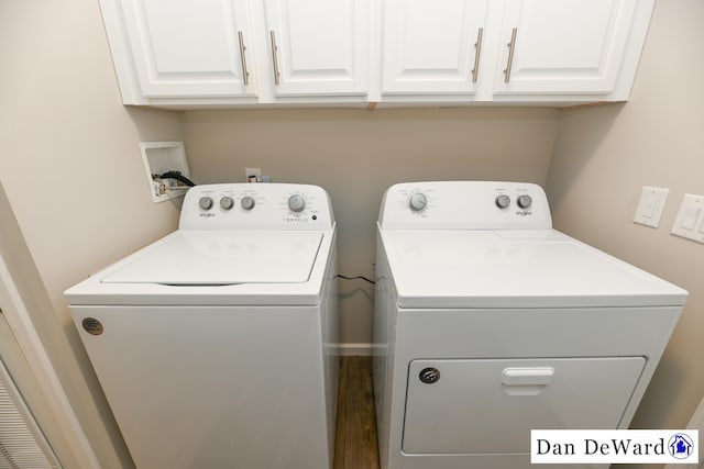 laundry area featuring hardwood / wood-style flooring, washer and clothes dryer, and cabinets