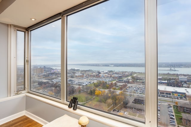 unfurnished sunroom with a water view and a city view