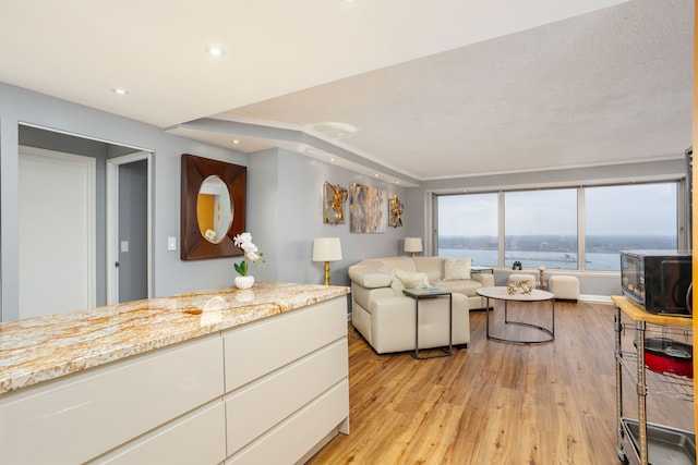 living area featuring light wood-style flooring, recessed lighting, and baseboards