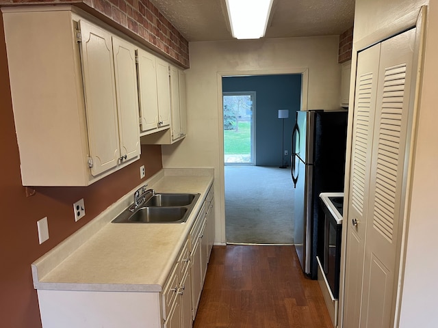 kitchen featuring dark hardwood / wood-style flooring, sink, white electric stove, white cabinetry, and stainless steel refrigerator