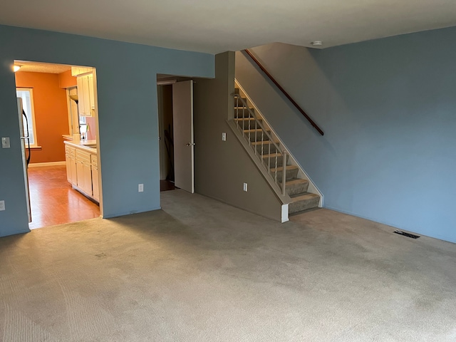 unfurnished living room featuring light carpet