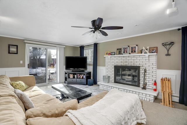 living room featuring ceiling fan, crown molding, and a brick fireplace