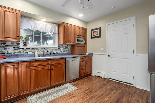 kitchen featuring dark hardwood / wood-style flooring, sink, appliances with stainless steel finishes, and a baseboard heating unit