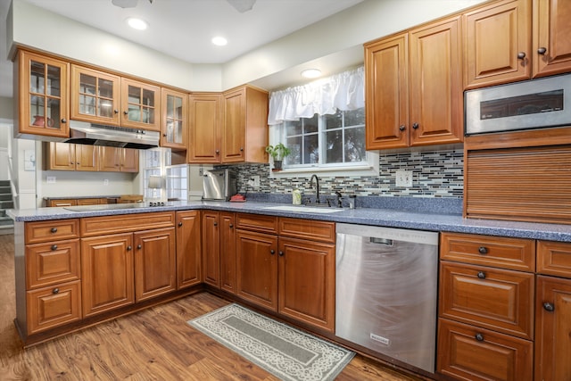 kitchen with backsplash, sink, stainless steel appliances, and light wood-type flooring