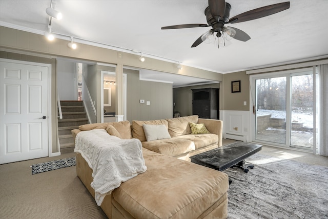 living room with baseboard heating, ceiling fan, track lighting, and ornamental molding