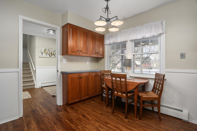 dining room featuring dark hardwood / wood-style floors, a chandelier, and a baseboard heating unit