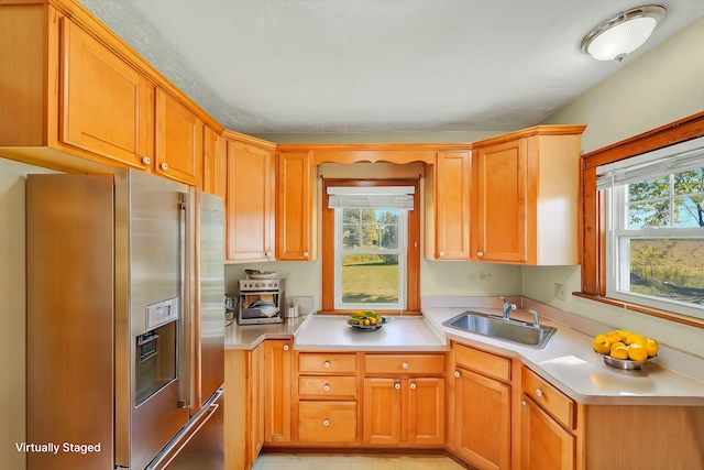 kitchen featuring stainless steel fridge with ice dispenser, a healthy amount of sunlight, and sink