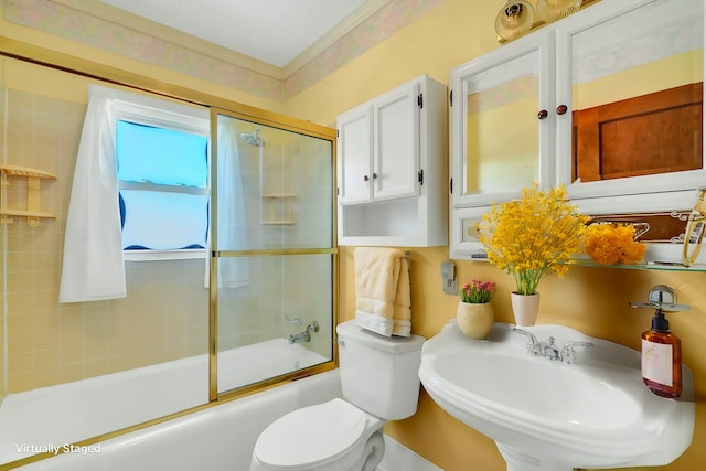 full bathroom featuring toilet, enclosed tub / shower combo, and sink